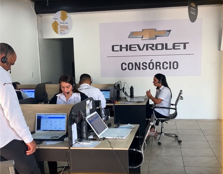 Operação de consórcio Chevrolet, com atendentes em mesas de trabalho