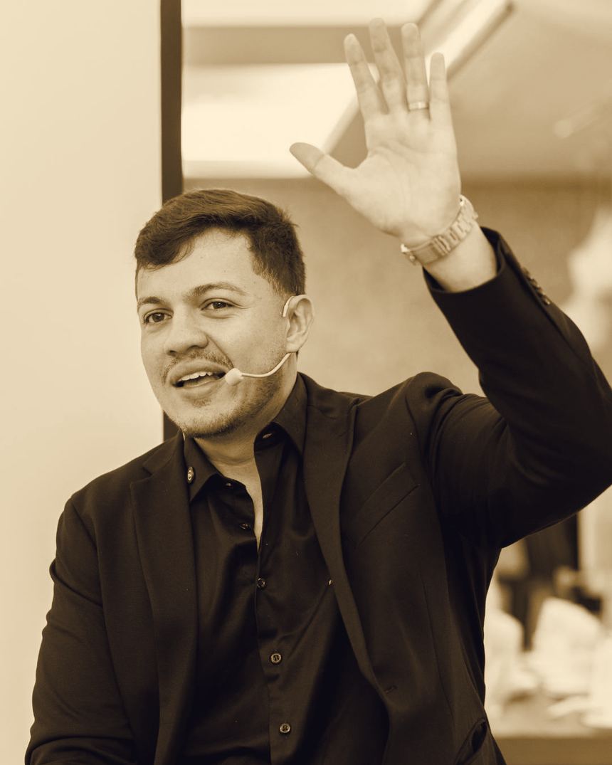 Paulo Espíndola com a mão levantada, falando ao público